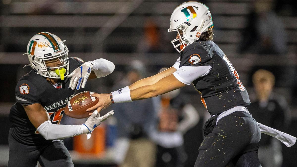 Frederick Douglass’ Samuel Cornett (10) hands off the ball to TJ Horton (15) during a Class 5A semifinal game against Owensboro at Frederick Douglass High School in Lexington, Ky., on Friday, Nov. 26, 2021.