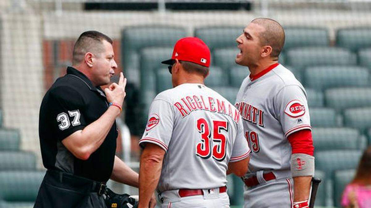 Cincinnati interim manager Jim Riggleman stood between first baseman Joey Votto and umpire Carlos Torres as they argued after Votto was ejected during the first inning of the Reds' 6-5 win at Atlanta on Wednesday.