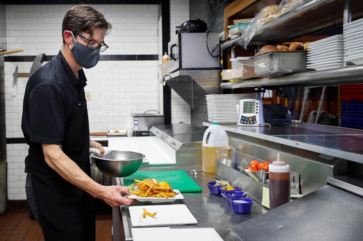 Chef Andrew Durbin, of Lexington, Ky., works to plate the Three B’s Burger at The Goose Lexington, Wednesday, May 5, 2021.