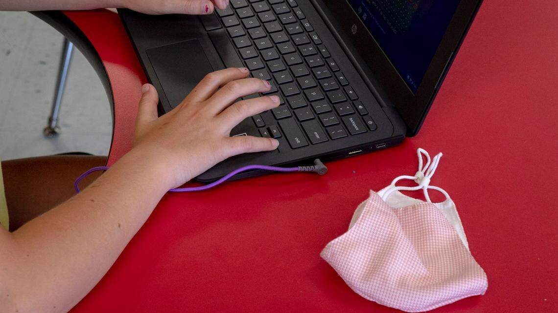A mask lays next to a school Chromebook.