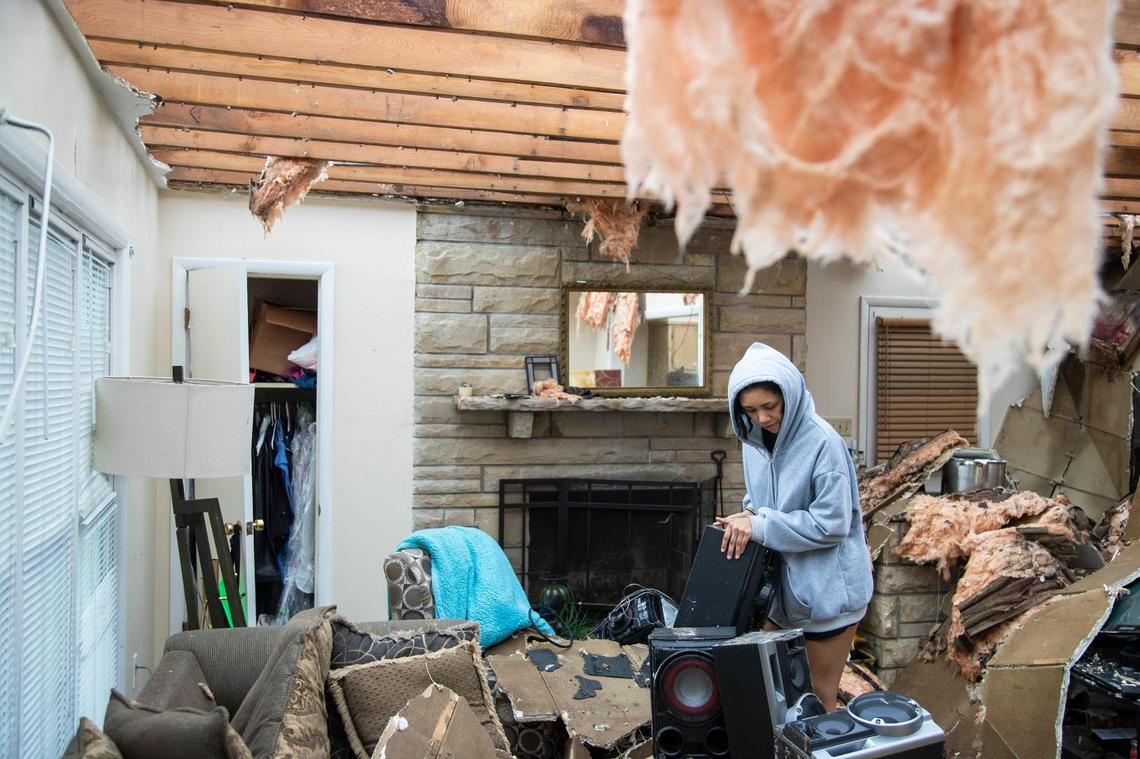 Adrian McDonald, 19, works to clear debris from her relatives home after a tornado took off the roof in Bowling Green, Ky., Saturday, December 11, 2021.