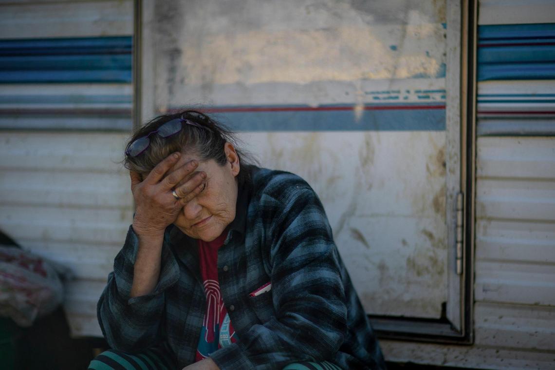 Melissa Bryant sits outside the travel trailer where she lives in Haddix, Ky., on Monday, Feb. 6, 2023. Following last summer’s floods, Bryant lived in a cargo trailer before a woman she first met following flooding two years ago gave Bryant the travel trailer in November. Bryant has 15 dogs and lives without electricity.