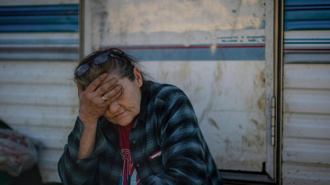 Melissa Bryant sits outside the travel trailer where she lives in Haddix, Ky., on Monday, Feb. 6, 2023. Following last summer’s floods, Bryant lived in a cargo trailer before a woman she first met following flooding two years ago gave Bryant the travel trailer in November. Bryant has 15 dogs and lives without electricity.