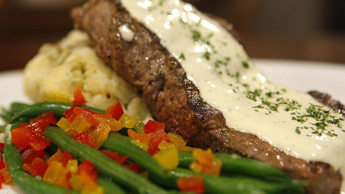 New York strip steak comes with mashed potatoes and green beans.
