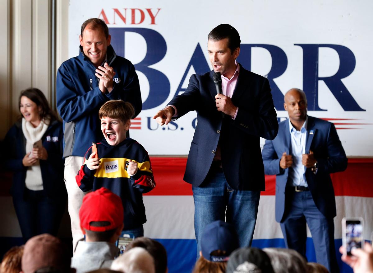 Eli Coons, 8-years-old from Mt. Sterling, reacted after Donald Trump Jr., right, called him to the stage as Trump Jr. made a campaign appearance for U.S. Rep. Andy Barr, left, Monday morning inside a hangar at the Montgomery County Airport in Mt. Sterling, Ky. Barr, a Republican incumbent, is running against Democratic Amy McGrath in Kentucky’s Sixth Congressional District.