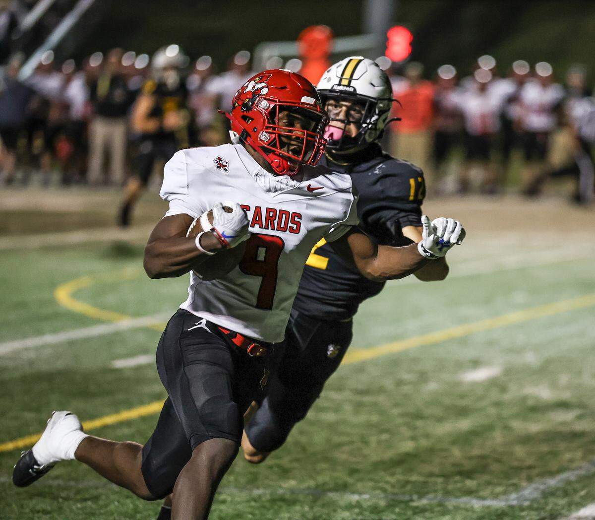 Scott County’s Timmy Emongo (9) tried to evade Woodford County’s Wyatt Peters during the Yellow Jackets’ 57-50 win over the Cardinals at Community Stadium in Versailles on Oct. 17.