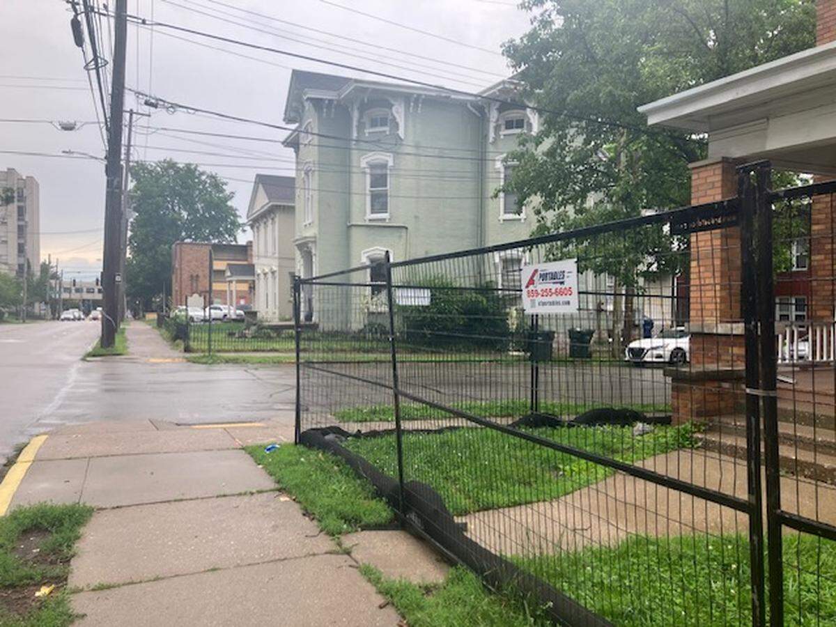 Buildings soon to be demolished are fenced in on East Maxwell near Lexington Avenue. Those buildings will be razed for a 6-story apartment complex. Lexington council recently approved a zone change for an 8-story building across from the 6-story apartments. 