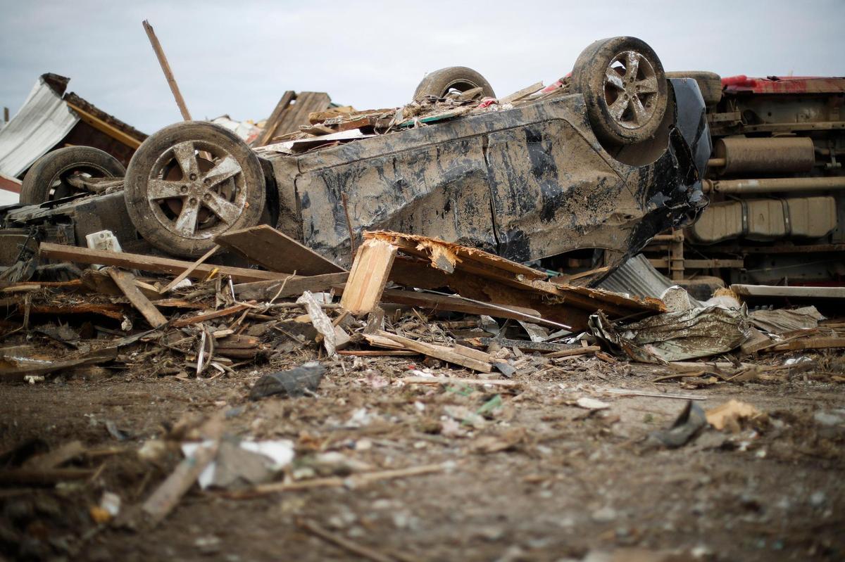 A Chevrolet sits on hits roof in behind Chili Motors on West Broadway in Mayfield, Ky., Wednesday, Dec. 15, 2021.