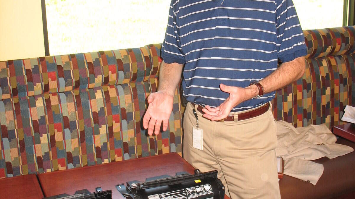 Andrew Gardner displayed two toner cartridges, an authentic one on the left and a counterfeit that was spray-painted black.