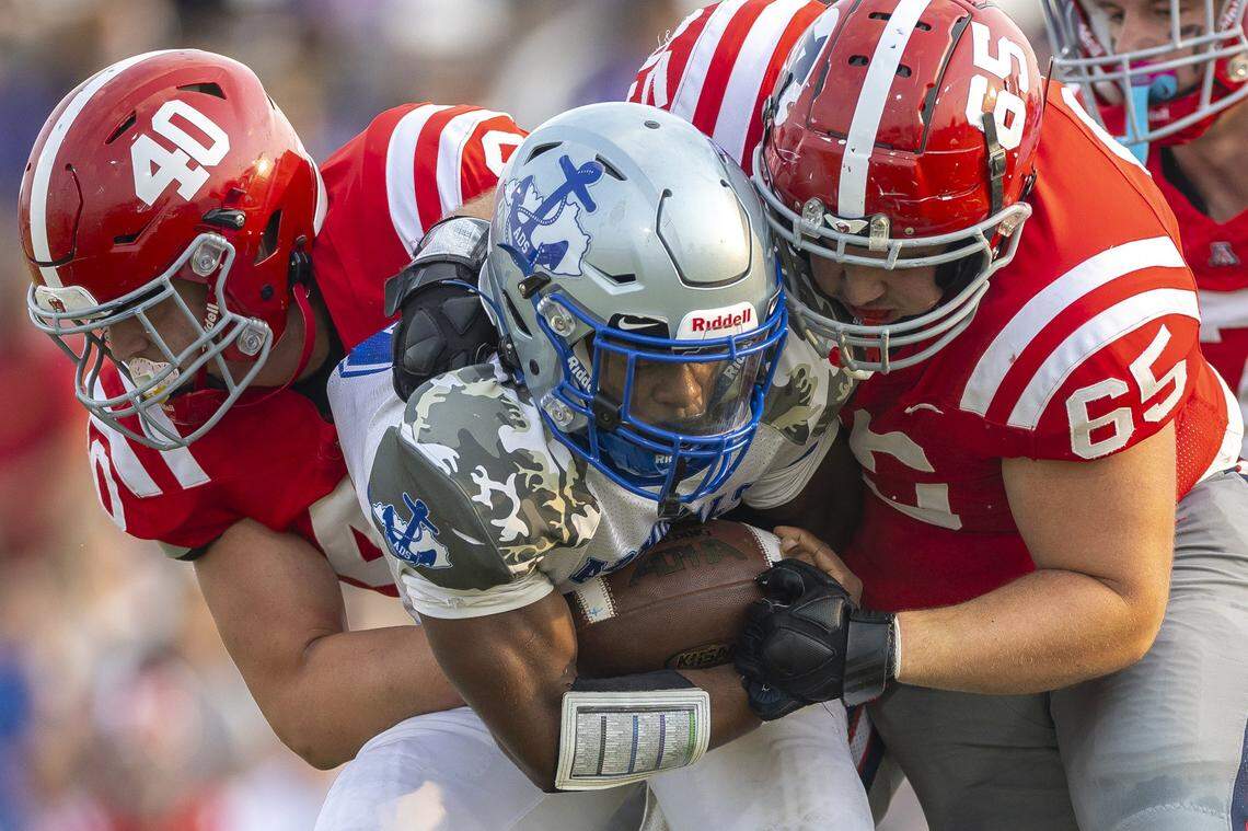 Danville's Jayvian Meaux (6) is wrapped up by Anderson County's Grayson Alsabrook (40) and Anderson County's Ezekial Pacheco (65) during a game in Lawrenceburg on Sept. 5.