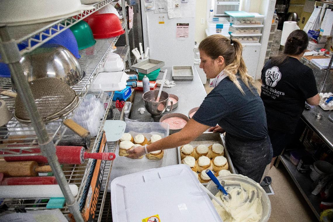 Jennie Walters, 21, frosts cinnamon rolls July 1 to fulfill a large order at Root-a-Baker Bakery in Morehead.
