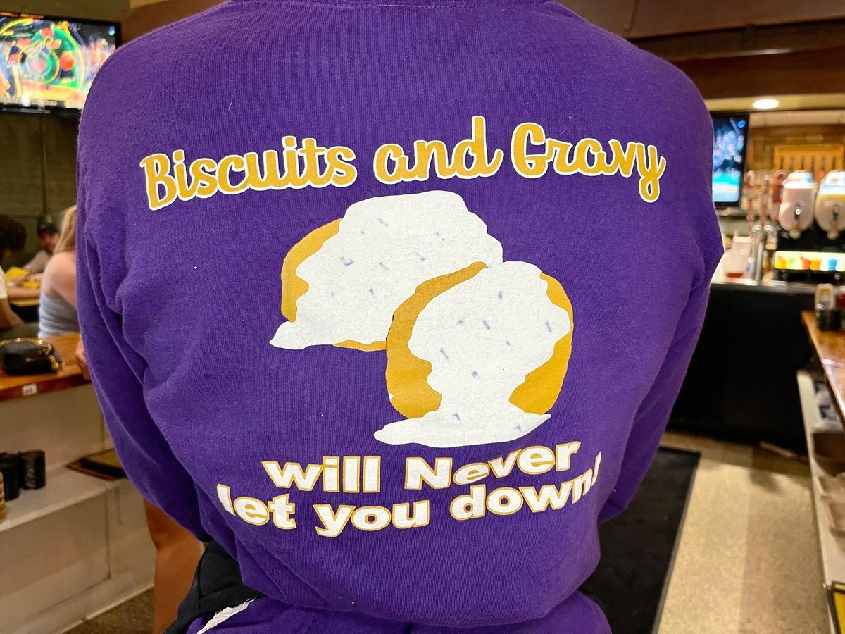 A server wears a T-shirt promoting biscuits and gravy from Josie’s that says “Biscuits and Gravy will Never let you down.”