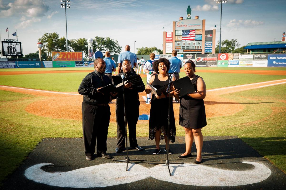 Michael Preacely, from left, leading members the group Virtuosity, Kaymon Murrah, Marquita Richardson and Michelle Taylor perform a combined version of “The Star-Spangled Banner” and “Lift Every Voice and Sing” June 26 at Lexington Legends Ballpark. The song was performed in conjunction with the launch of the “I Was Here” project instillation by artist Marjorie Guyon at the ballpark.