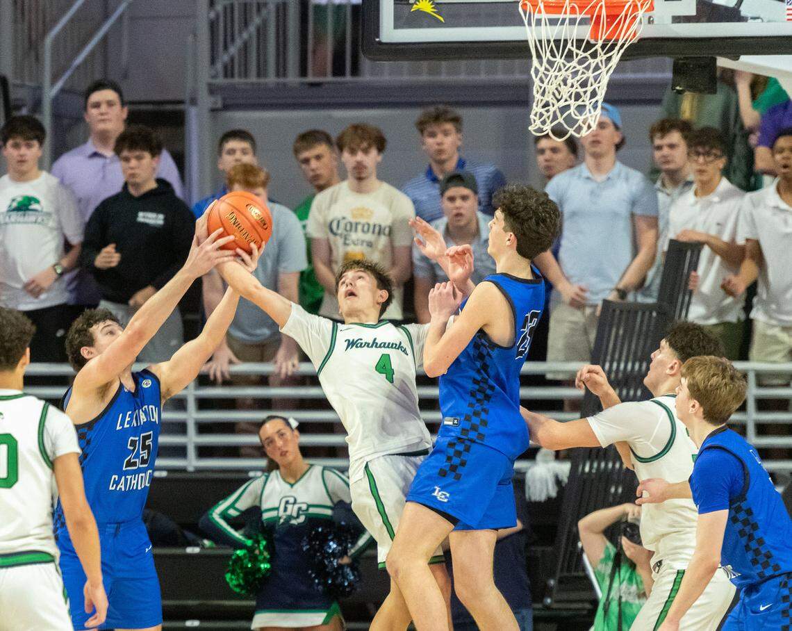 Great Crossing's Graham Swartz (4) fights for a rebound with Lexington Catholic's Ashton Pflugner in the Warhawks' 50-42 win in the boys 11th Region Tournament semifinals at Eastern Kentucky University’s Baptist Health Arena in Richmond on Saturday.
