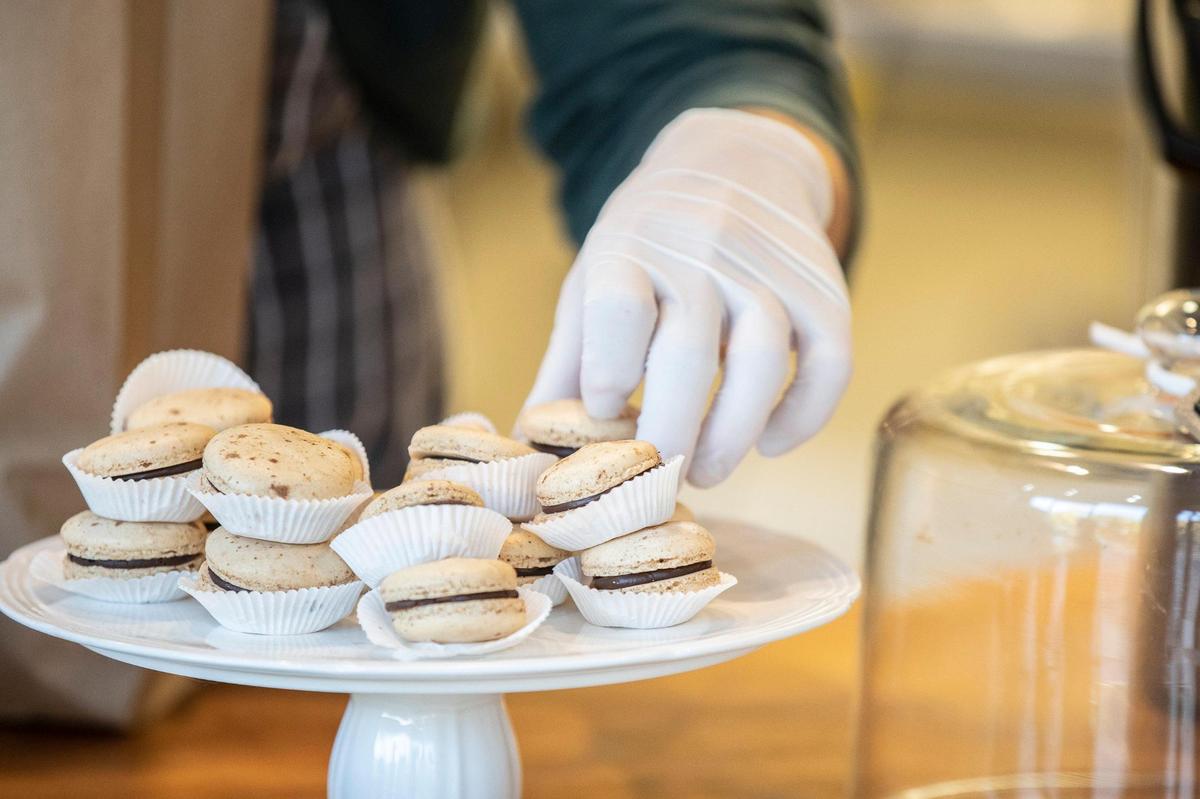 Daniel King, Futile Bakery owner and baker, selects a macaron for a customer Thursday at the bakery at 399 Waller Ave., Suite 130.