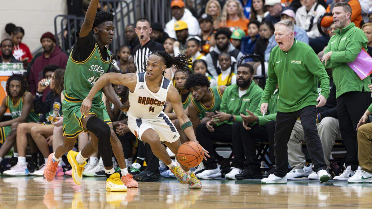Frederick Douglass point guard Dakari Talbert (4) eludes a trap led by Bryan Station’s Kolako Roberts, left, as Defenders’ coach Champ Ligon, right, shouts instructions during the boys 42nd District Tournament championship game at Bryan Station High School on Friday.
