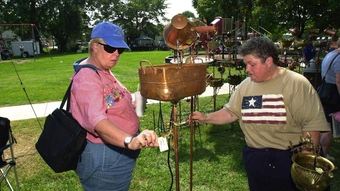 In this file photo, Joan Rush, left, of Atlanta, checks out the price tag of the fountains as  fountain maker Mary Martin, of Nolensville,Tenn.,  shows some models to her at the Spoonbread  Festival  in Berea. Rush bought the fountain.