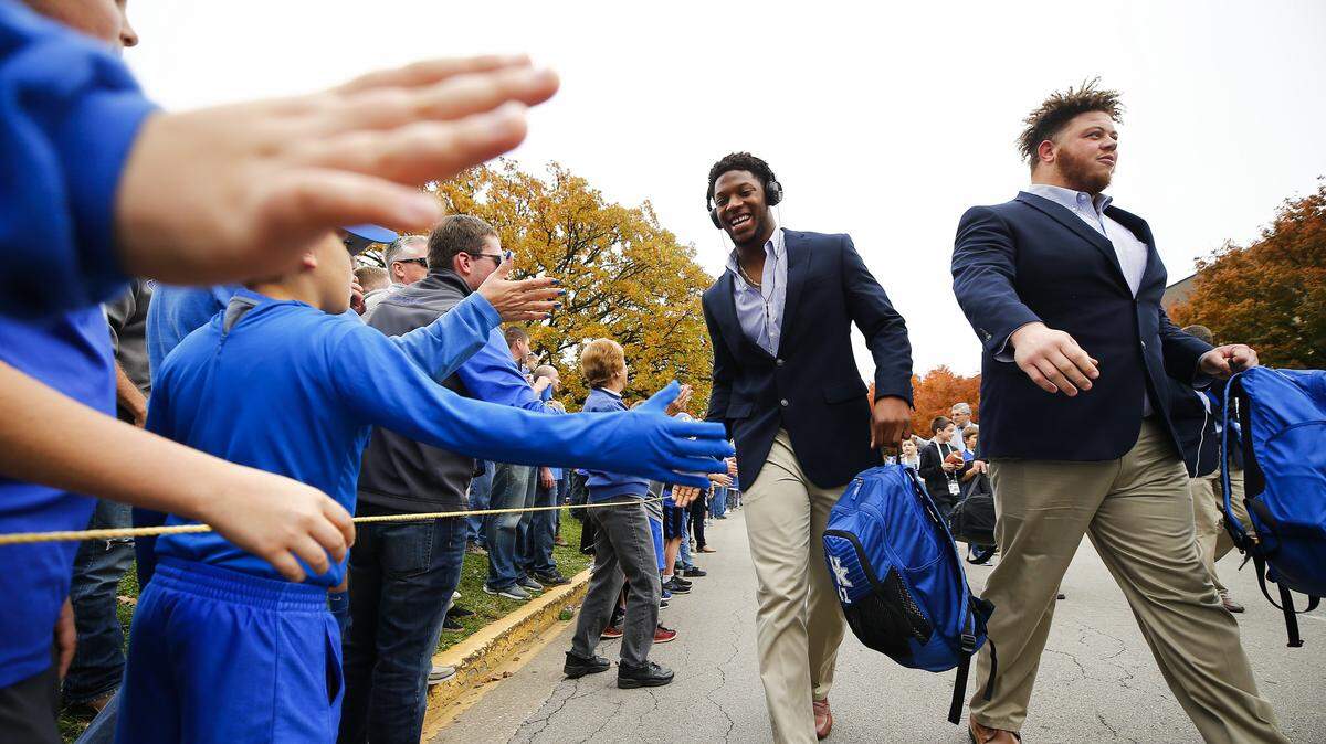 Kentucky’s Josh Allen, left, and Matt Elam were greeted by fans during the Cat Walk before the team’s game against Mississippi at Kroger Field on Nov. 4, 2017.