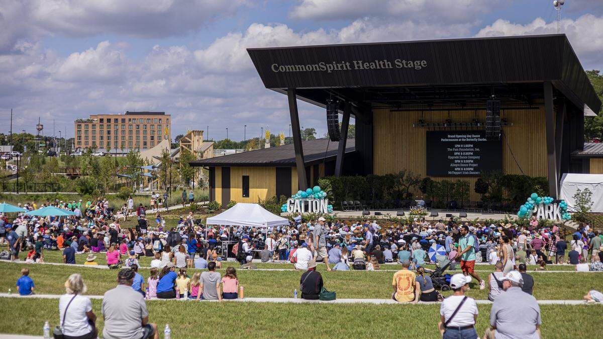 People sit on the grass to hear from speakers during the opening of Gatton Park on Saturday, Aug. 23, 2025, in Lexington, Ky. 