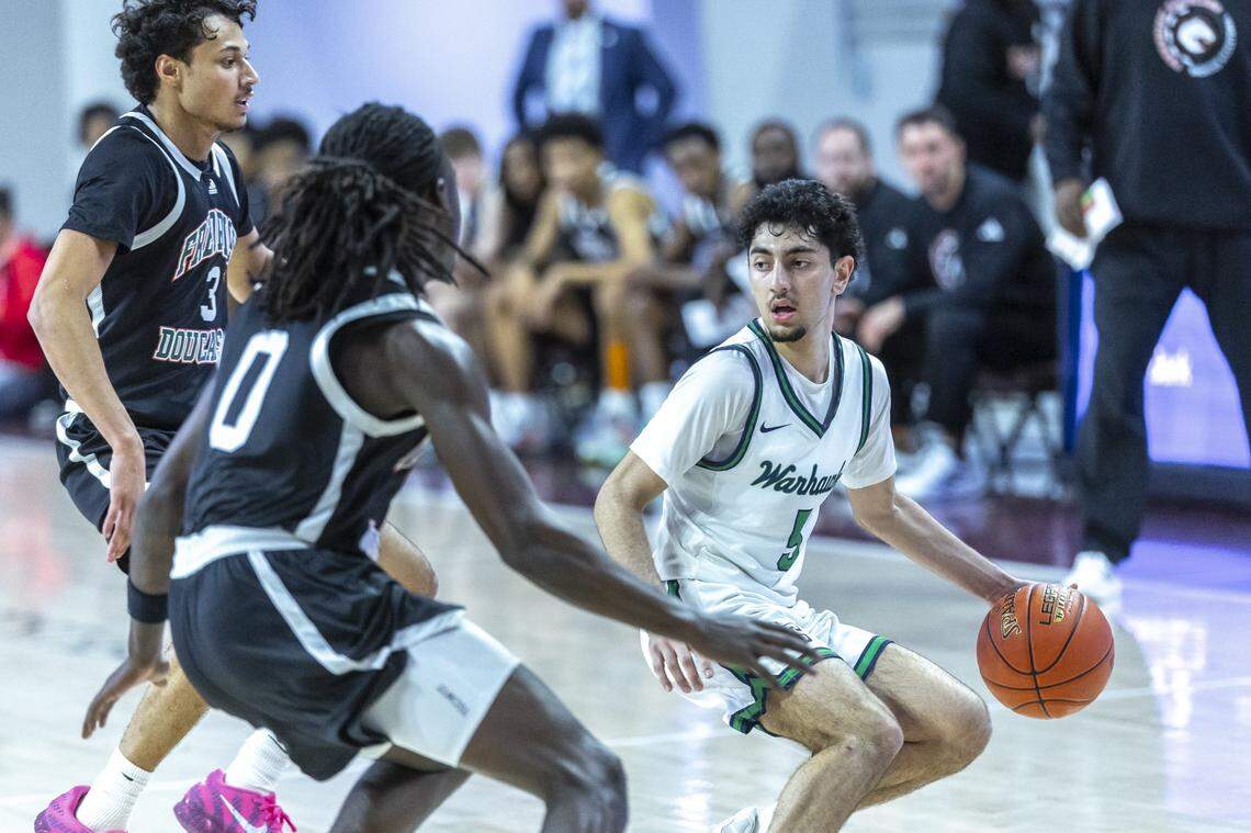 Great Crossing's Aslam Ismail (5) looks to move the ball as Frederick Douglass' Thurman Wade (0) defends during the Boys 11th Region Tournament championship game at Eastern Kentucky University's Baptist Health Arena in Richmond, Ky., on Monday, March 9, 2026.