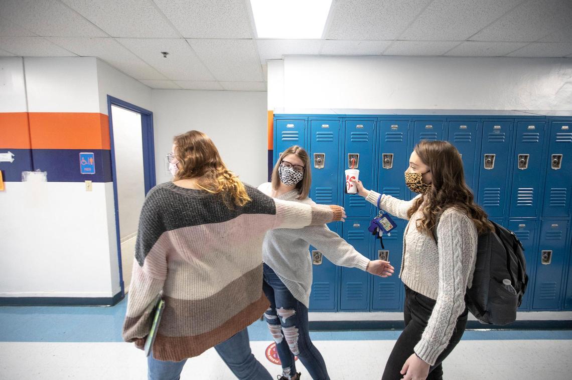 Macy Dungan, center, a senior at Frankfort High School in Frankfort, Ky., greets her friends, Tatum Williams, left, and Hailey Close, between classes on Monday, Feb. 8, 2021, the first day senior students were allowed to attend in-person classes at the school in nearly a year.
