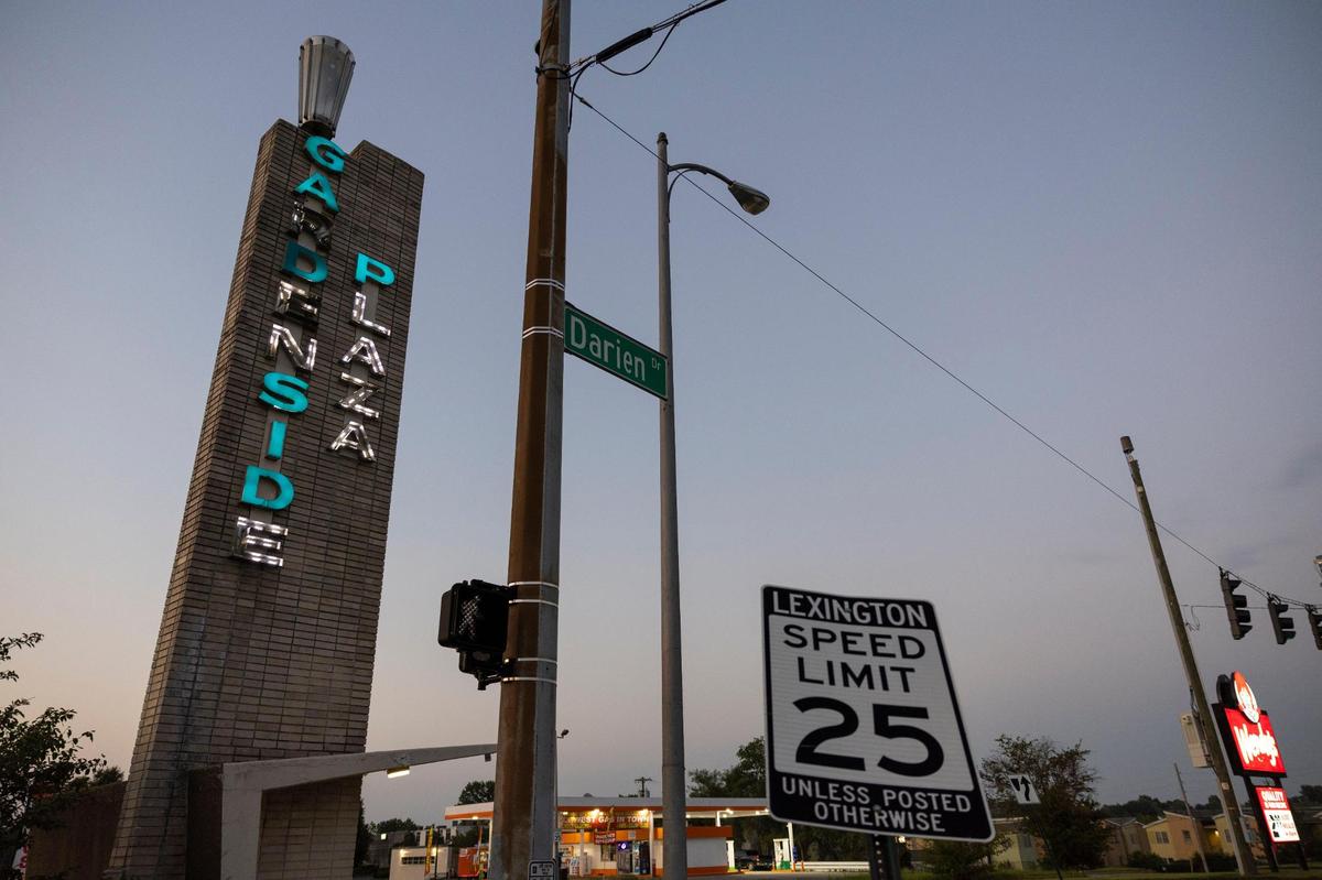 The sun sets behind a sign for Gardenside Plaza in Lexington, Ky, Friday, July 28, 2023.