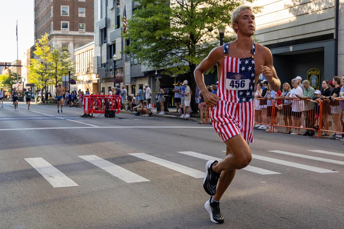 A patriotic James Barnett runs to the finish line during Friday’s Bluegrass 10,000.