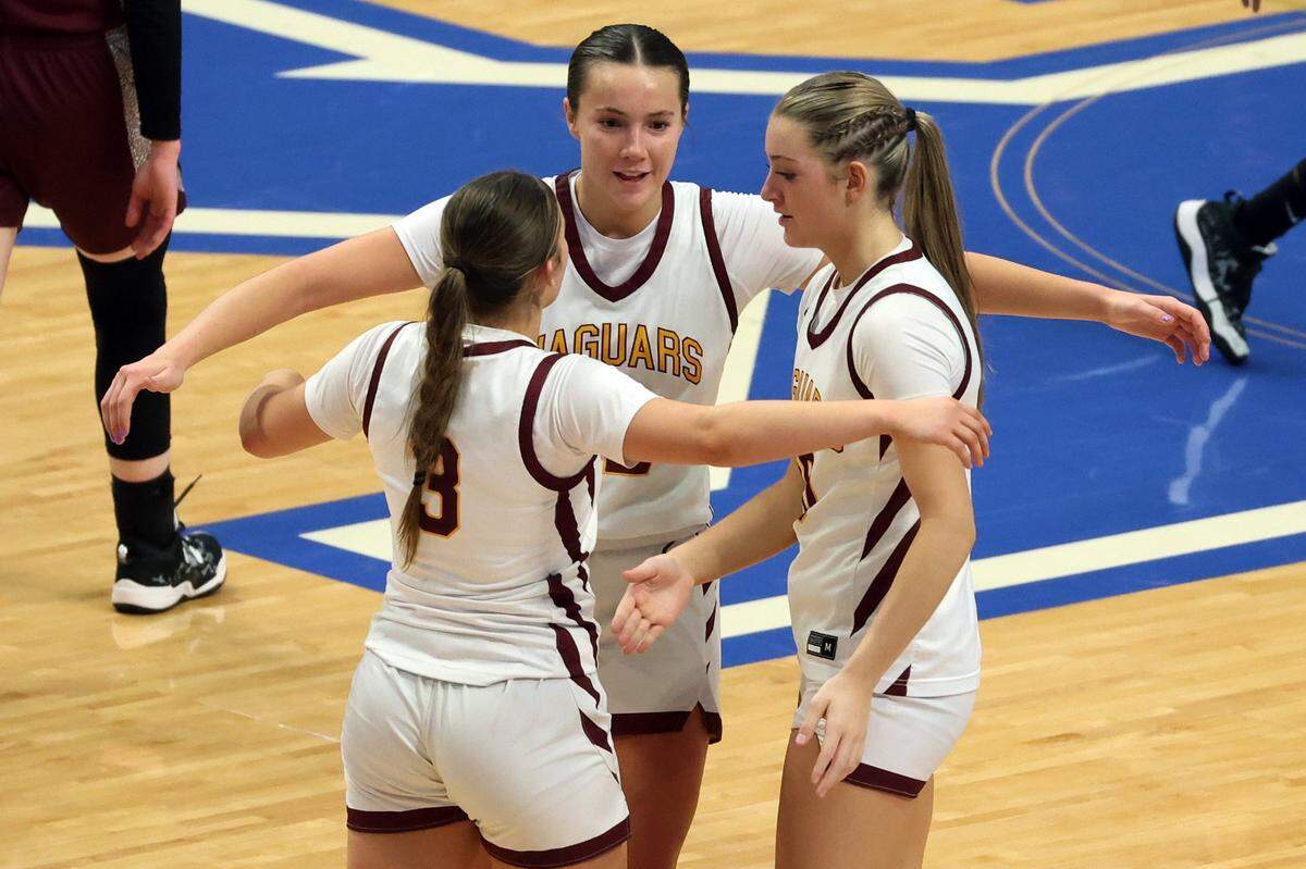 Cooper’s Addyson Brissey, Liz Freihofer, and Haylee Noel hug after winning their quarterfinal game against Henderson County in Rupp Arena on Friday night.