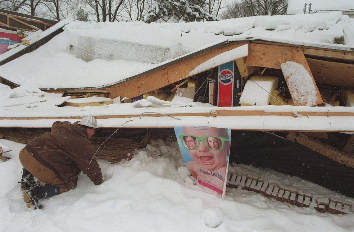 Willis Bastin looks at what's left of the Movie Warehouse at Euclid and Park Ave. on Friday February 6, 1998. The building collapsed under the weight of the snow.