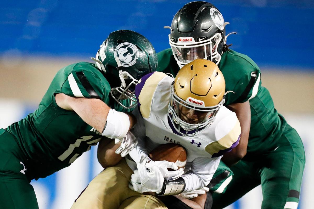 Trinity’s Brandon Stearman (13), Blake Ruffin (16) and Roman White (21) tackled Male’s Vincel Anthony during Saturday night’s game at Kroger Field. The Shamrocks limited Male to 141 yards of offense in the shutout.