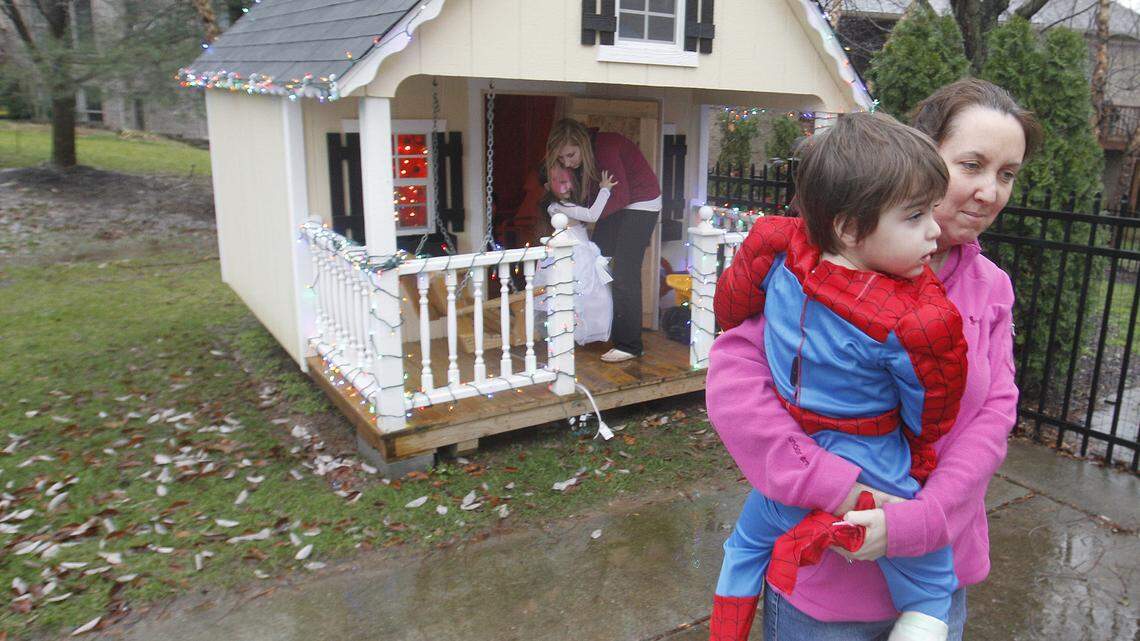 In April 2011, Dr. George and Tiffiney Veloudis (right) installed an enclosed playhouse for their son Cooper (being carried) at their then-home in the Andover Forest subdivision, a structure which was prohibited by restrictions on the homeowners' deeds.  