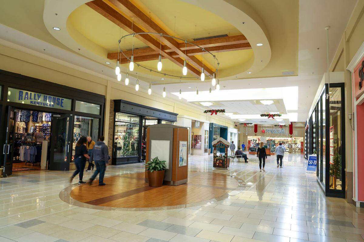 NOW: Shoppers walk towards Macy’s in Fayette Mall, Friday, Dec. 13, 2024 in Lexington, Ky. The picture is taken from the same vantage point as the image above.
