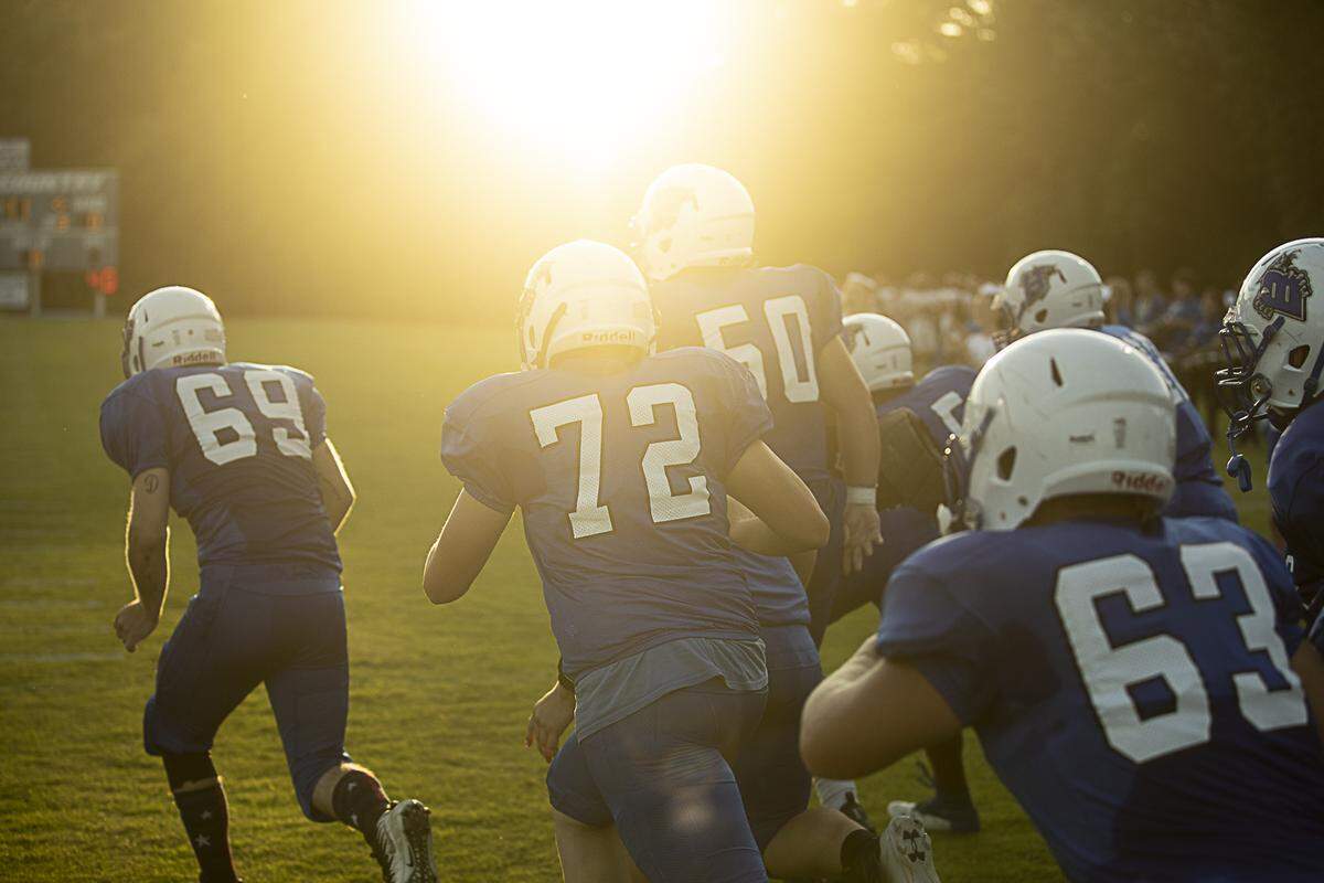 The Bobcats take the field in their game against South Laurel as the sun sets.