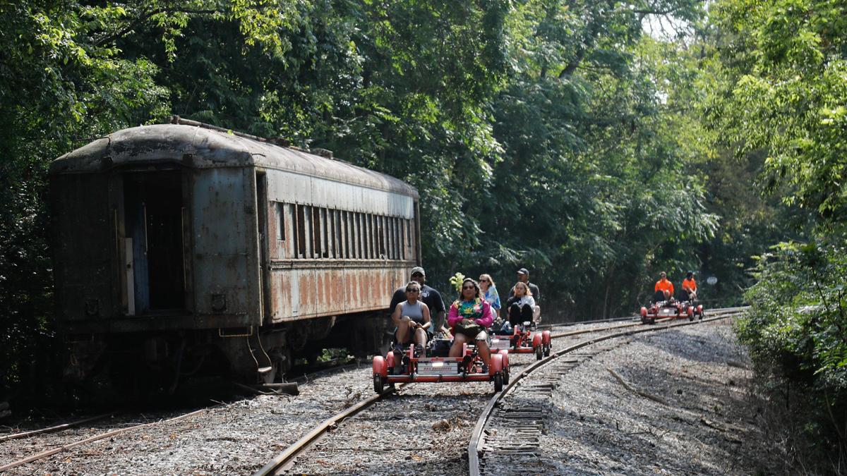 Visitors riding “Rail Explorers” pass an abandoned train car on Friday, Aug. 4, 2023 at the Bluegrass Scenic Railroad and Museum in Versailles, Ky.