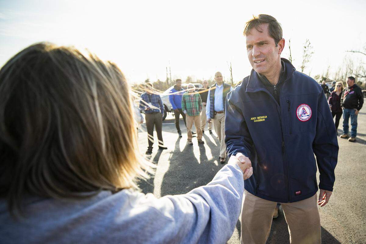 Amy Arnold, of Bremen, Ky., greets Kentucky Gov. Andy Beshear as he examines damage at Church Street General Baptist Church in Bremen, Ky., Tuesday, Dec. 14, 2021. 