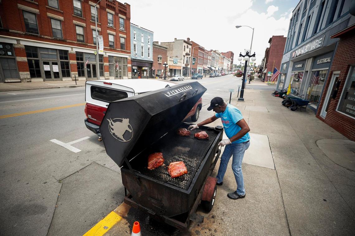 Kenny Allen checks on his smoker set up in front of In and Out BBQ June 24 at the corner of North Main Street and West Broadway in downtown Winchester. Allen has been cooking since he was 14 and has owned In and Out for nearly five years.