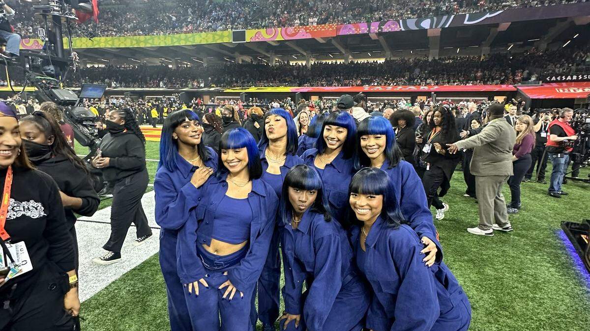 Kendal Hughley and other dancers from the Super Bowl halftime show posed on the field.