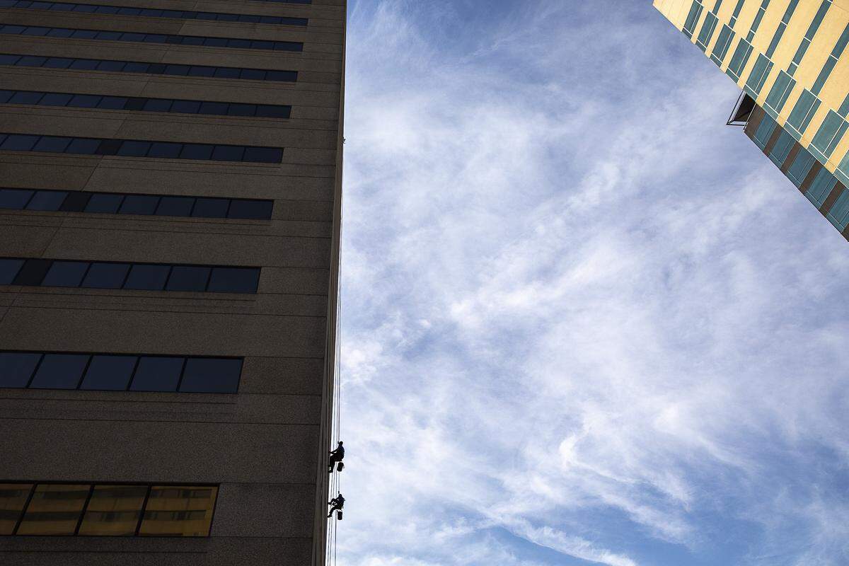 Chris Scholer, top, and Howard Newby, of Braco Window Cleaning, wash windows at the Vine Center at 333 West Vine St. in downtown Lexington, Wednesday, June 26, 2019.