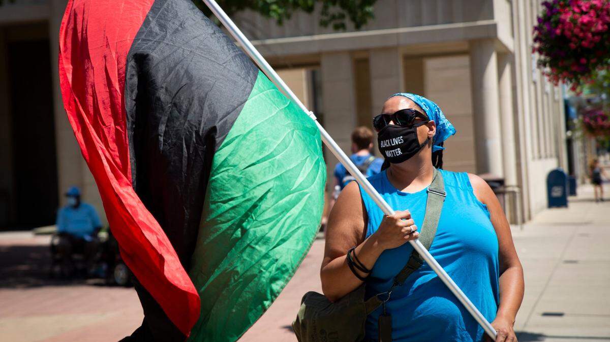 Sarah Williams holds a Pan-African flag during the United Campus Workers of Kentucky and Black Lives Matter protest in Lexington, Ky., on Saturday, July 11, 2020.