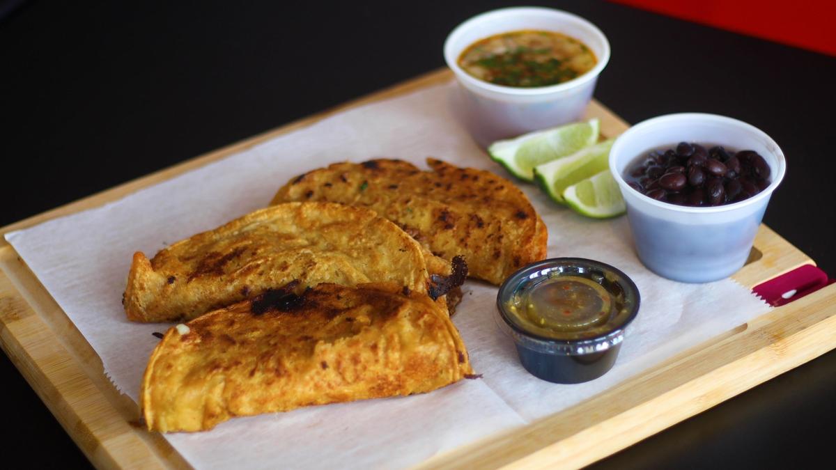A barbacoa meat taco can be served at El Cid with a side of the birria consomme to dip into.