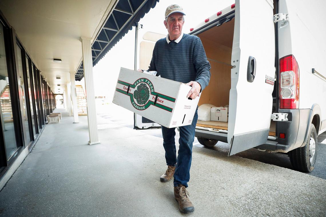 Mac Stone, a farmer at Elmwood Stock Farm, delivers a CSA box of fresh vegetables Wednesday to the Lexington Seafood Company. Stone says business has increased since the spread of coronavirus.