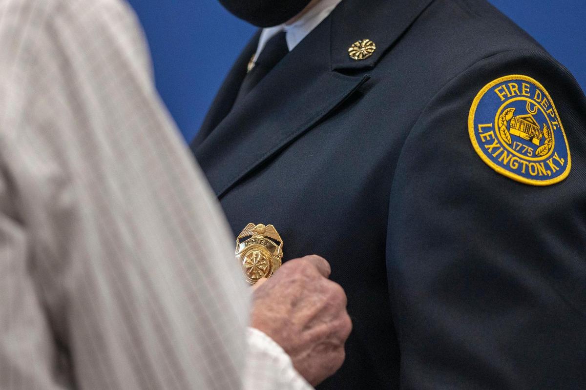 Jason Wells, the new chief of the Lexington Fire Department, had his new badge pinned on his uniform by his father, Jim Wells, who served 27 years with the fire department.