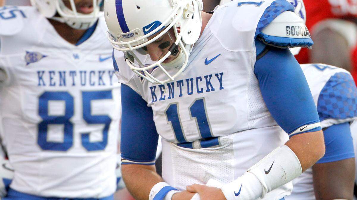 UK quarterback Maxwell Smith 
walked off the field clutching his arm late in the fourth quarter against Georgia.