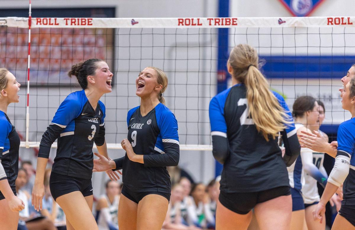 Lexington Catholic’s Addie Lowe (3) and Shay Pope (9) react to winning a point against Great Crossing during the 11th Region volleyball tournament semifinals at Madison Central High School in Richmond on Tuesday.
