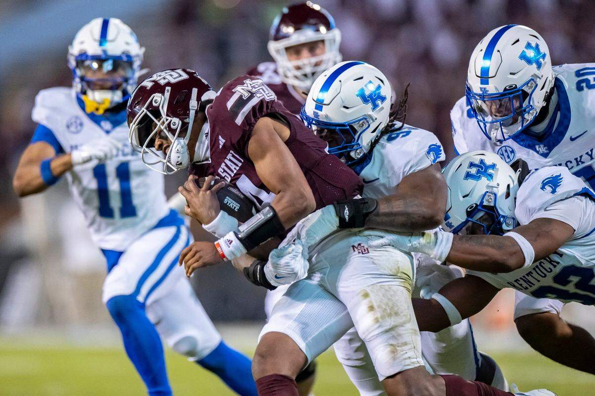Mississippi State quarterback Mike Wright (14) is brought down by Kentucky defensive lineman Jamarius Dinkins (95) during Saturday’s game.