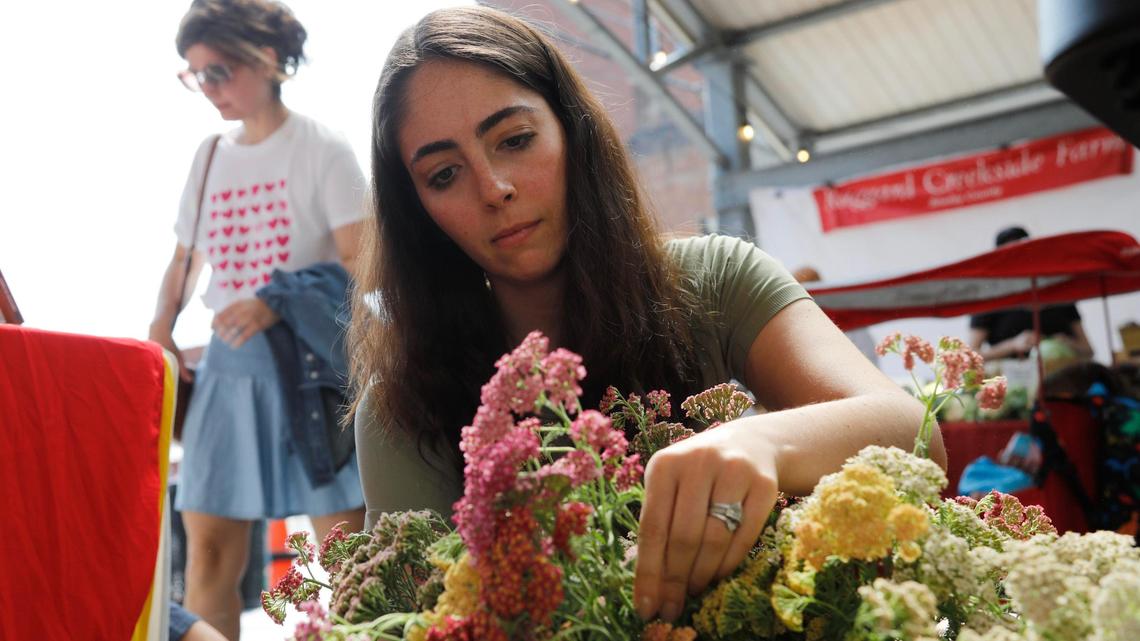 Claire Pauley arranges flowers for sale on Saturday, June 24, 2023 at Fifth Third Pavilion in Lexington, Ky.