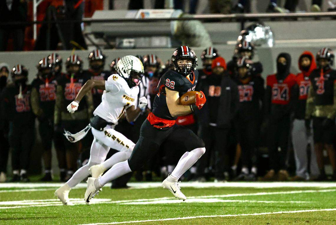Owensboro’s Evan Hampton (22) eludes the pursuit of Woodford County’s Christopher Reed Jr. during the Red Devils’ win in the Class 5A state semifinals at Rash Stadium in Owensboro on Nov. 28.