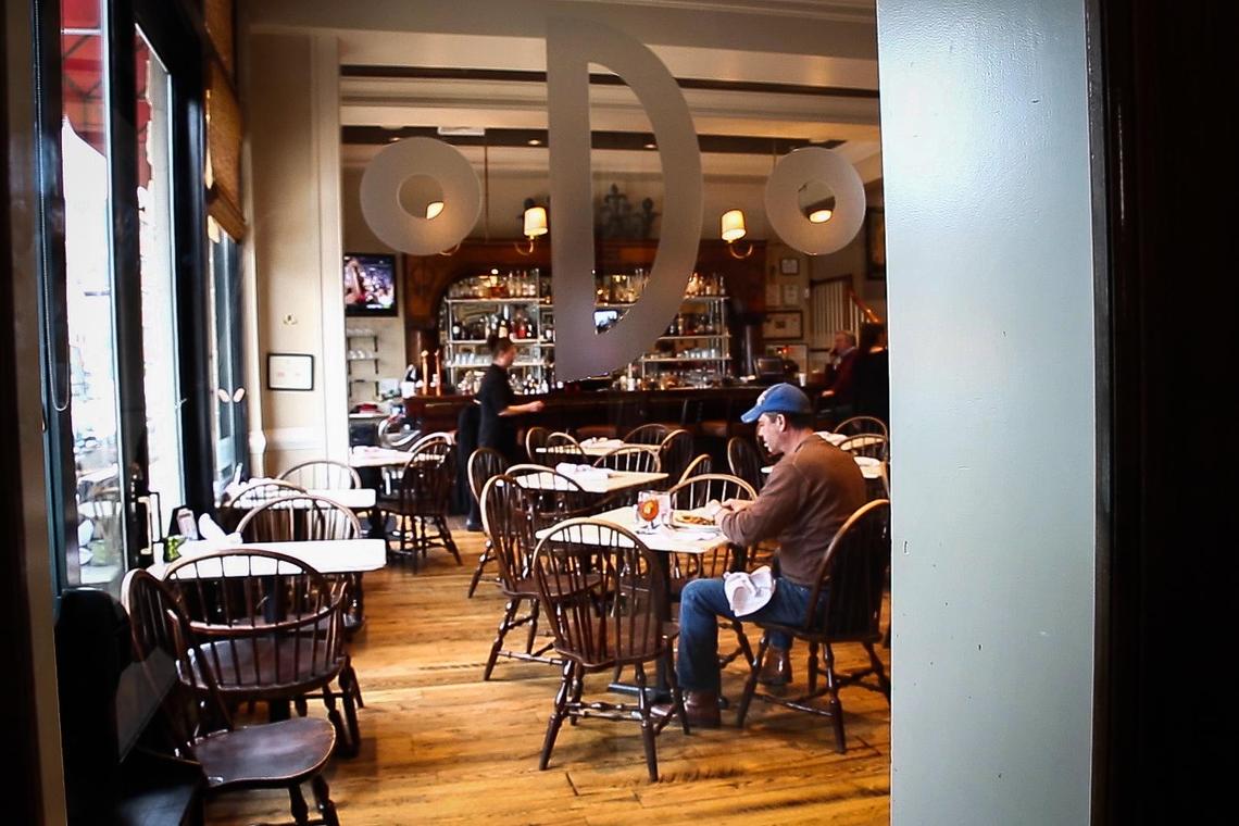 Patrons eat lunch Monday at Dudley’s On Short in Lexington. Dudley’s will likely close rather than try to stay open for carryout orders in the wake of the governor’s order.