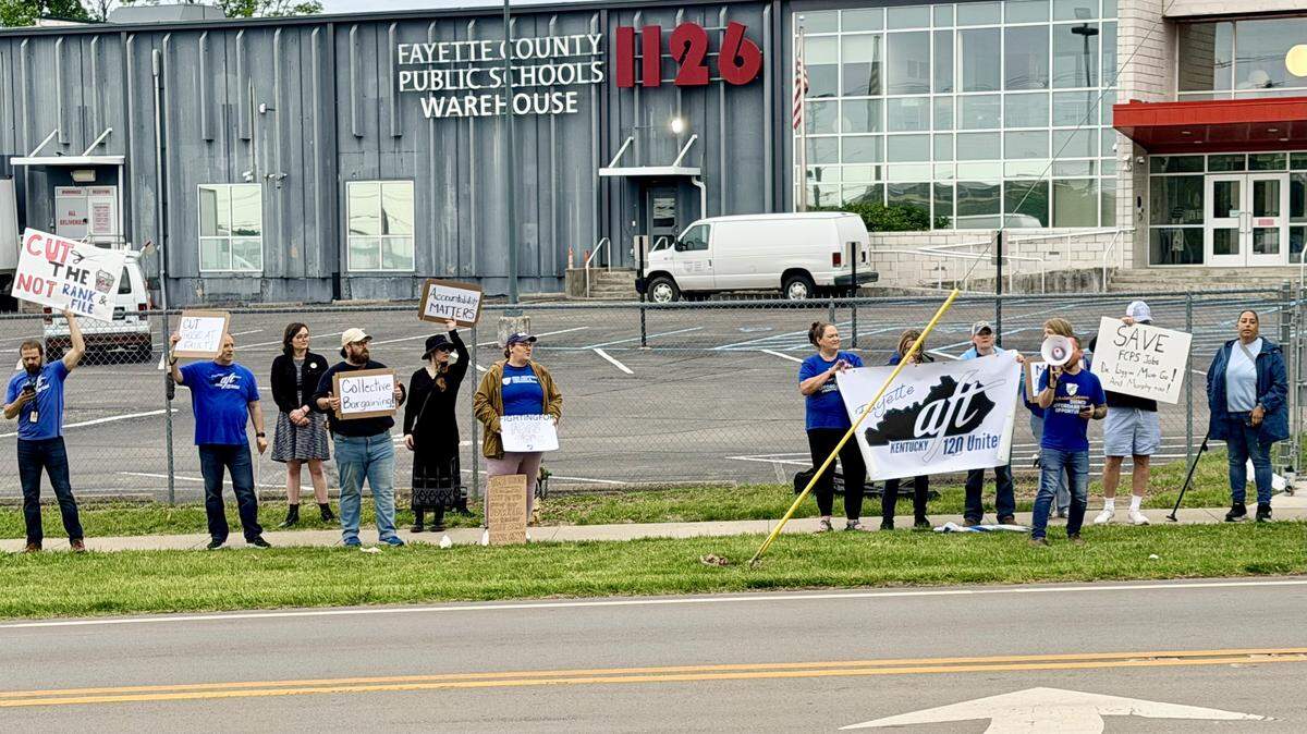 Protesters gather outside the Fayette County Public Schools Central Office in Lexington, Ky., to speak out against district layoffs.