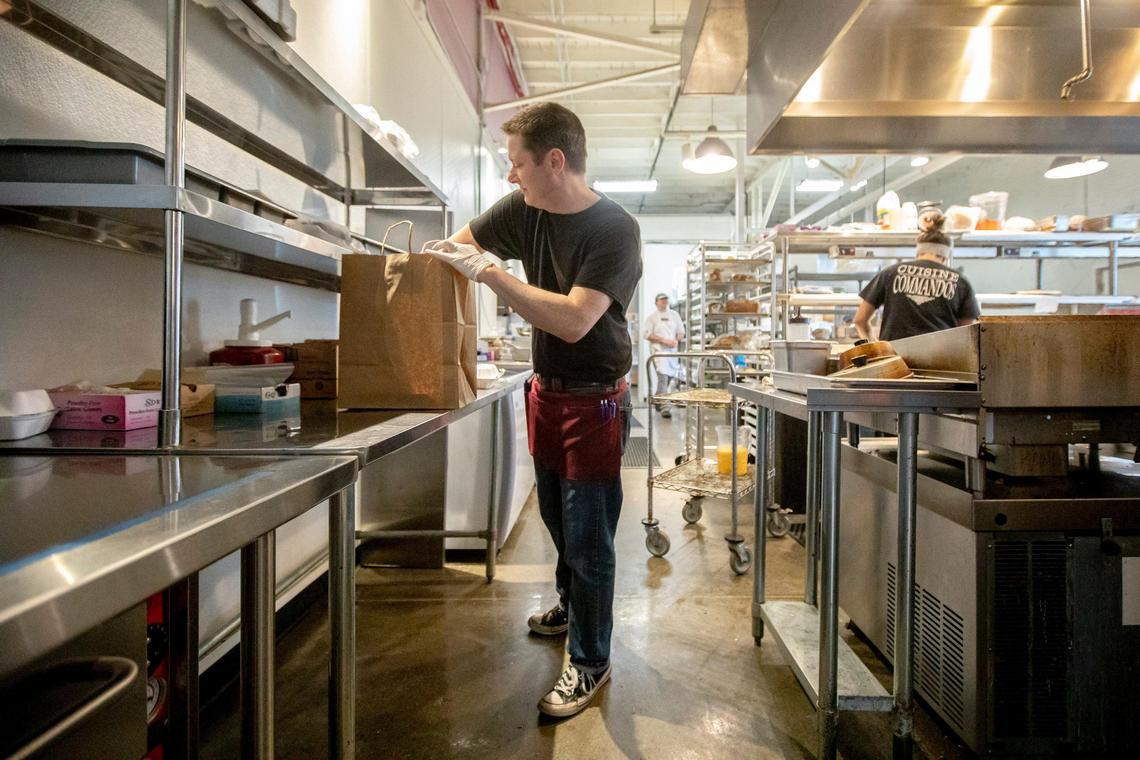 Kevin McPherson packs up a to-go order Friday at Epping’s on Eastside on Lexington’s Main Street.